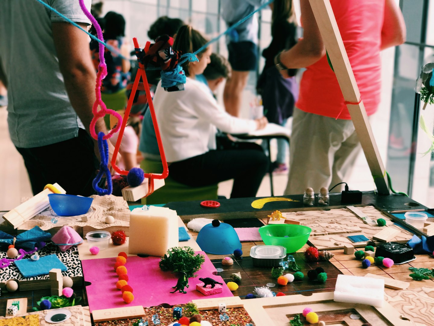 Persone che collaborano a progetti artigianali con materiali colorati.